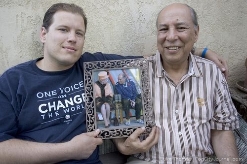 Adriel with his uncle Dr. Eber Hampton, holding a framed photo of Eber with Queen Elizabeth II